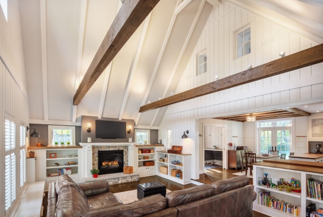 Entertainment space created in the original garage with soaring ceiling and exposed beams