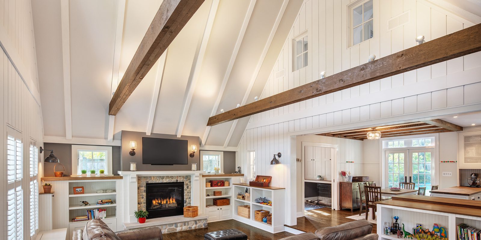 Entertainment space created in the original garage with soaring ceiling and exposed beams